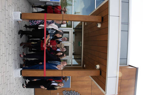 Group photo of ribbon cutting ceremony in front of the detachment building